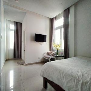 um quarto com uma cama e uma televisão na parede em Phuong Vy 2 em Da Lat