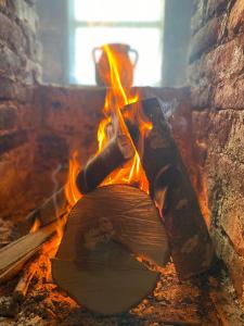 un focolare con un pezzo di legno e fiamme di Cottage Modrich a Struga