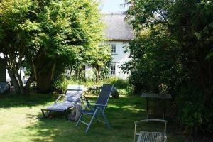 twee stoelen en een grill in een tuin bij Forsythia cottage with surf and cycle hire in Wrafton