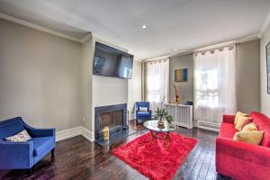 a living room with a red couch and a fireplace at Riverfront Harrisburg Home Less Than 1 Mi to Dtwn! in Harrisburg