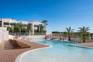 duży basen z krzesłami i palmami w obiekcie Holiday Apartment Lotus 45 La Cala w mieście La Cala de Mijas