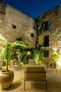 a patio with couches and a plant in front of a building at Isabella di Castiglia Apartments in Siracusa