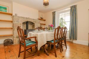 a dining room with a table and chairs and a fireplace at 1 Dormer Villas in Porthscatho