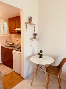 a small kitchen with a white table and a table and chair at Filoxenia Apartments in Mytilini