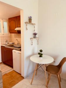 a small kitchen with a white table and a table and chair at Filoxenia Apartments in Mytilene +117 photos