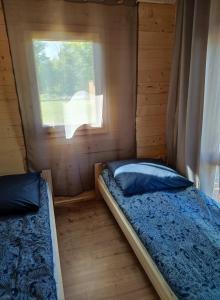 een slaapkamer met 2 bedden in een blokhut bij Laguna Zastań in Zastań