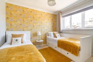 ブロードステアーズにあるOnyx Bay - Whole Apartment - WiFi - Beach - 2 Bed - Broadstairs Townの黄色の壁紙のベッドルーム1室(ベッド2台付)