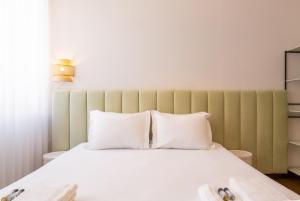 a bedroom with a large bed with white pillows at ORM- Flores Apartment in Porto