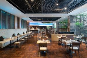 a restaurant with tables and chairs and a bar at Swissotel Bangkok Ratchada in Bangkok