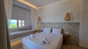 a bedroom with a bed and a window with a couch at Hotel Alexandra in Skala