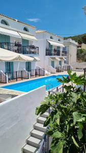 a building with a swimming pool next to a building at Hotel Alexandra in Skala
