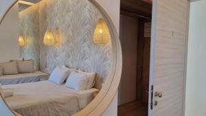 a mirror in a bedroom with a bed with white pillows at Hotel Alexandra in Skala