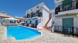 a villa with a swimming pool in front of a building at Hotel Alexandra in Skala