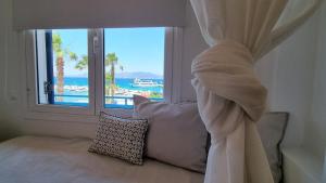 a bedroom with a window with a view of the ocean at Hotel Alexandra in Skala