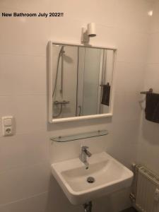 a white bathroom with a sink and a mirror at Loetje in Gosau +38 photos
