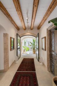 um corredor com uma entrada arqueada e um tapete em Isabella di Castiglia Apartments em Siracusa