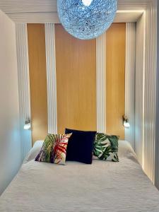 łóżko z dwoma poduszkami i żyrandolem nad nim w obiekcie Edifício Hercules w mieście Benalmádena