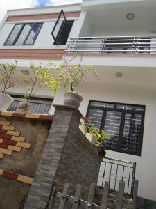 uma casa com dois vasos de plantas numa parede de tijolos em Rustic Homestay - Phòng nghỉ giá rẻ em Hai Phong
