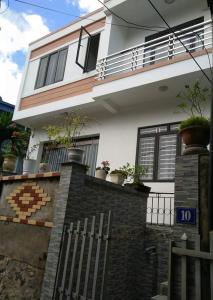 uma casa branca com vasos de plantas em cima de uma cerca em Rustic Homestay - Phòng nghỉ giá rẻ em Haiphong