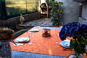 une table avec des assiettes et des verres à vin dessus dans l'établissement Casa Charo Prexigueiro, à Ribadavia 16 autres photos