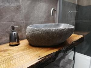 a bathroom with a stone sink on a wooden counter at CITYMAP HOTEL APPARTMENTS Maribor-Free parking! in Maribor +12 photos