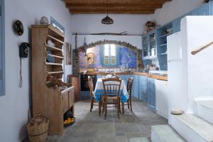 a kitchen with blue cabinets and a table and chairs at Elegant island house in Khatzirádhos