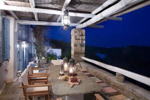 a patio with a table and chairs at night at Elegant island house in Khatzirádhos