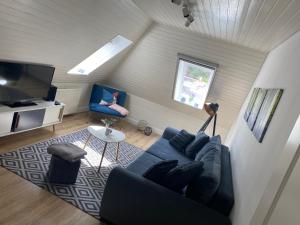 ein Wohnzimmer mit einem blauen Sofa und einem TV in der Unterkunft 38 Waldweg in Bendestorf