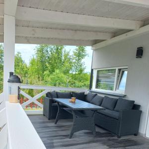 a patio with a couch and a table on a deck at Apartamenty u Beaty in Rewal