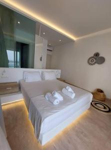 a bedroom with a large white bed with towels on it at Hotel Alexandra in Skala