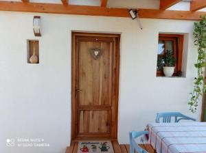 eine Holztür in einem weißen Haus mit einem Tisch in der Unterkunft Éva Vendégház in Cserszegtomaj