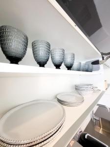 a shelf with four bowls and plates on it at Celta Home in Vigo