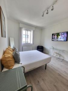 Un dormitorio con una gran cama blanca y una mesa en Celta Home, en Vigo