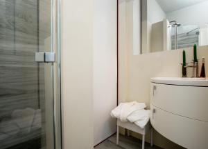 a white bathroom with a sink and a shower at Homey Experience - Marina Loft in La Maddalena