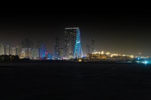 una città illuminata di notte con una città di Wyndham Residences The Palm a Dubai