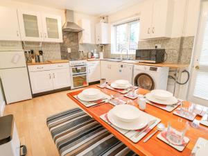 a kitchen with a wooden table with plates on it at Avaelie House in Hebden Bridge