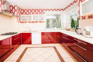 a kitchen with red cabinets and a window at Mazury całoroczny dom do wynajęcia nad jeziorem Sasek Wielki in Pasym