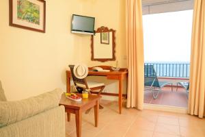 a living room with a couch and a table with a desk at Hotel Sant Roc in Calella de Palafrugell