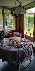 een tafel met eten in de woonkamer bij La Cour Du Puits Chambre Victor in Cormeilles