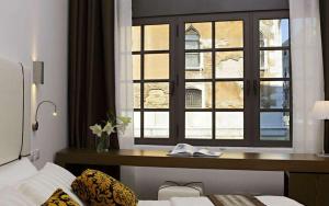 1 dormitorio con ventana, escritorio y cama en Al Canal Regio - Guest House, en Venecia