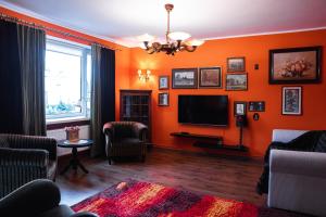 un soggiorno con pareti arancioni e TV a schermo piatto di Apartament z widokiem a Gdynia