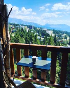 - une tasse de café assise sur une table sur un balcon dans l'établissement Les Balcons d'Edelweiss, à Chamrousse