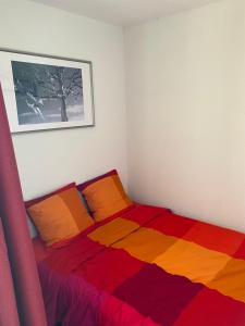 1 dormitorio con 1 cama con una manta colorida en Les Balcons d'Edelweiss, en Chamrousse