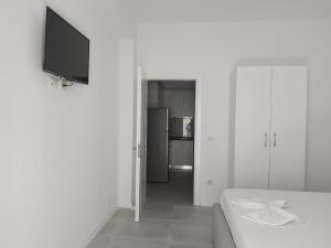 a white room with a couch and a television at Vila Jona Palasë in Dhërmi