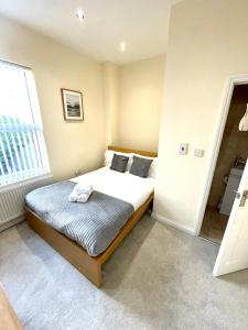 a bedroom with a bed and a window at Coventry Large Sleeps 5 Person 4 Bedroom 4 Bath House Suitable for BHX NEC Solihull Rugby Warwick Contractors Ricoh Arena NHS Short & Long Business Stays Free Parking for 2 Vehicles, Close to City Centre High Speed Wifi in Coventry