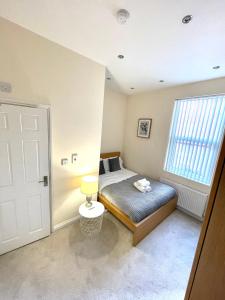 a small bedroom with a bed and a window at Coventry Large Sleeps 5 Person 4 Bedroom 4 Bath House Suitable for BHX NEC Solihull Rugby Warwick Contractors Ricoh Arena NHS Short & Long Business Stays Free Parking for 2 Vehicles, Close to City Centre High Speed Wifi in Coventry