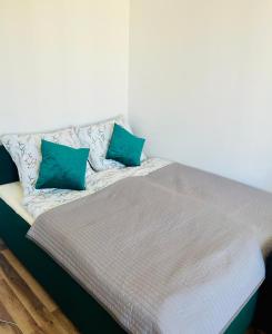 a bed with two blue pillows on top of it at Apartament na Spółdzielczej in Radzyń Podlaski