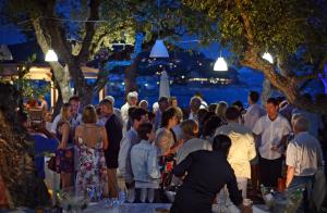 a group of people standing around at a party at night at Hotel Sant Roc in Calella de Palafrugell