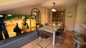 a dining room with a table and a large screen tv at Apartamentos Formigal - Admite mascotas in Formigal