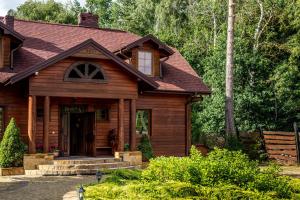 a home with a wooden house with a porch at Sielski Dworek in Chodel